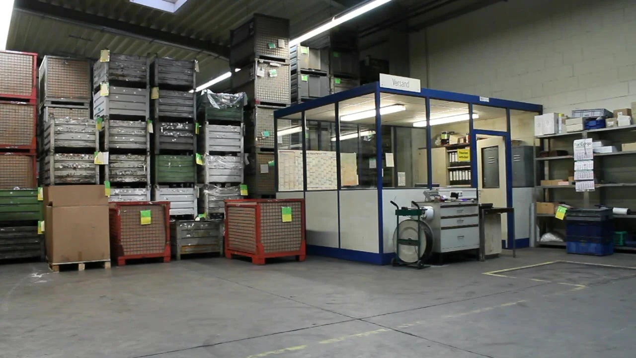 Lager mit Gitterboxen und Meisterbüro in der Halle