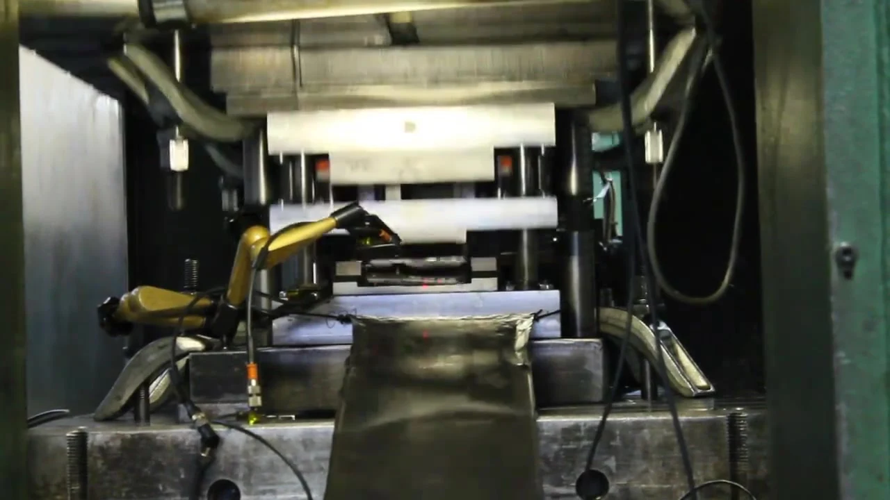 Roboterarm an einer Presse legt ein Teil in das Werkzeug, Szene aus dem Imagefilm